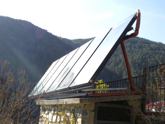 Paneles solares en casa cerca de una montaña